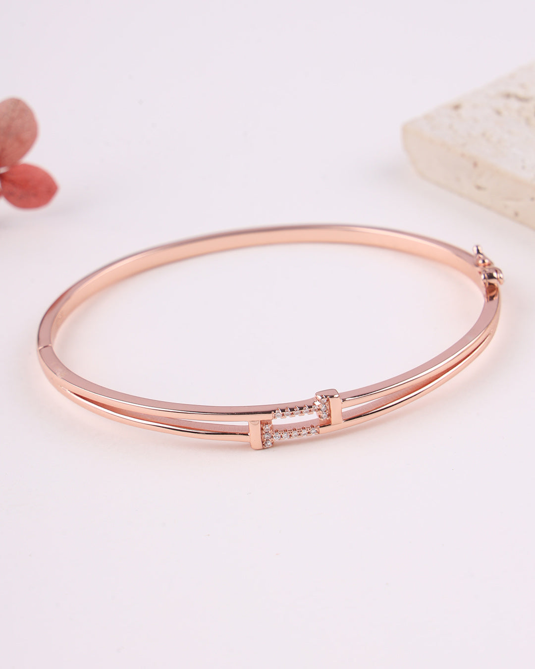 Rose gold bracelet on a light pink background