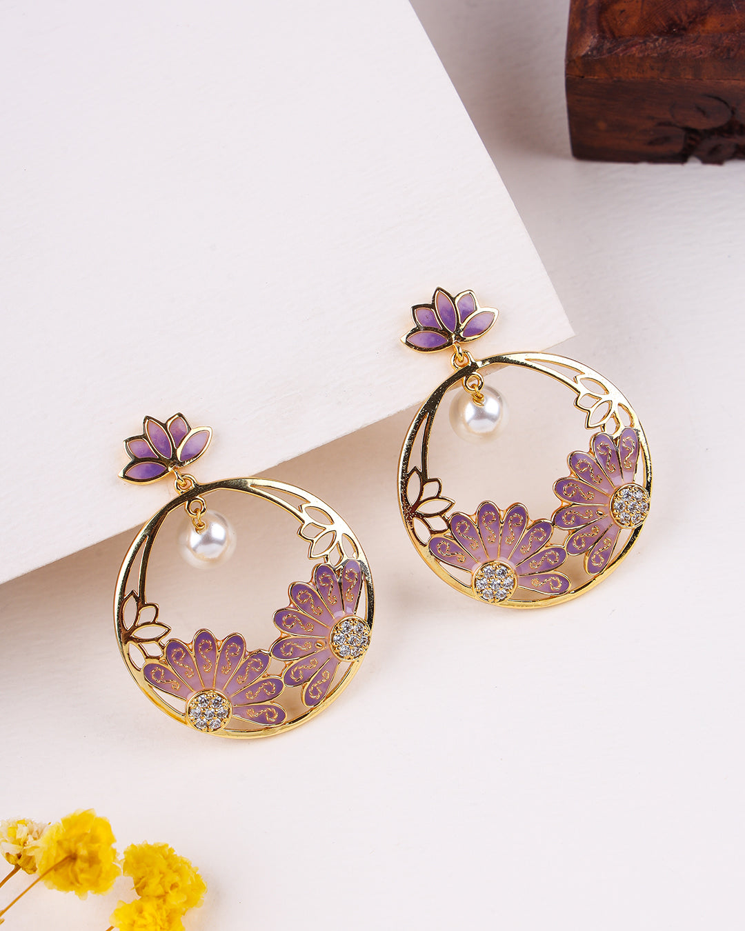 Pair of gold and purple floral earrings on a light background