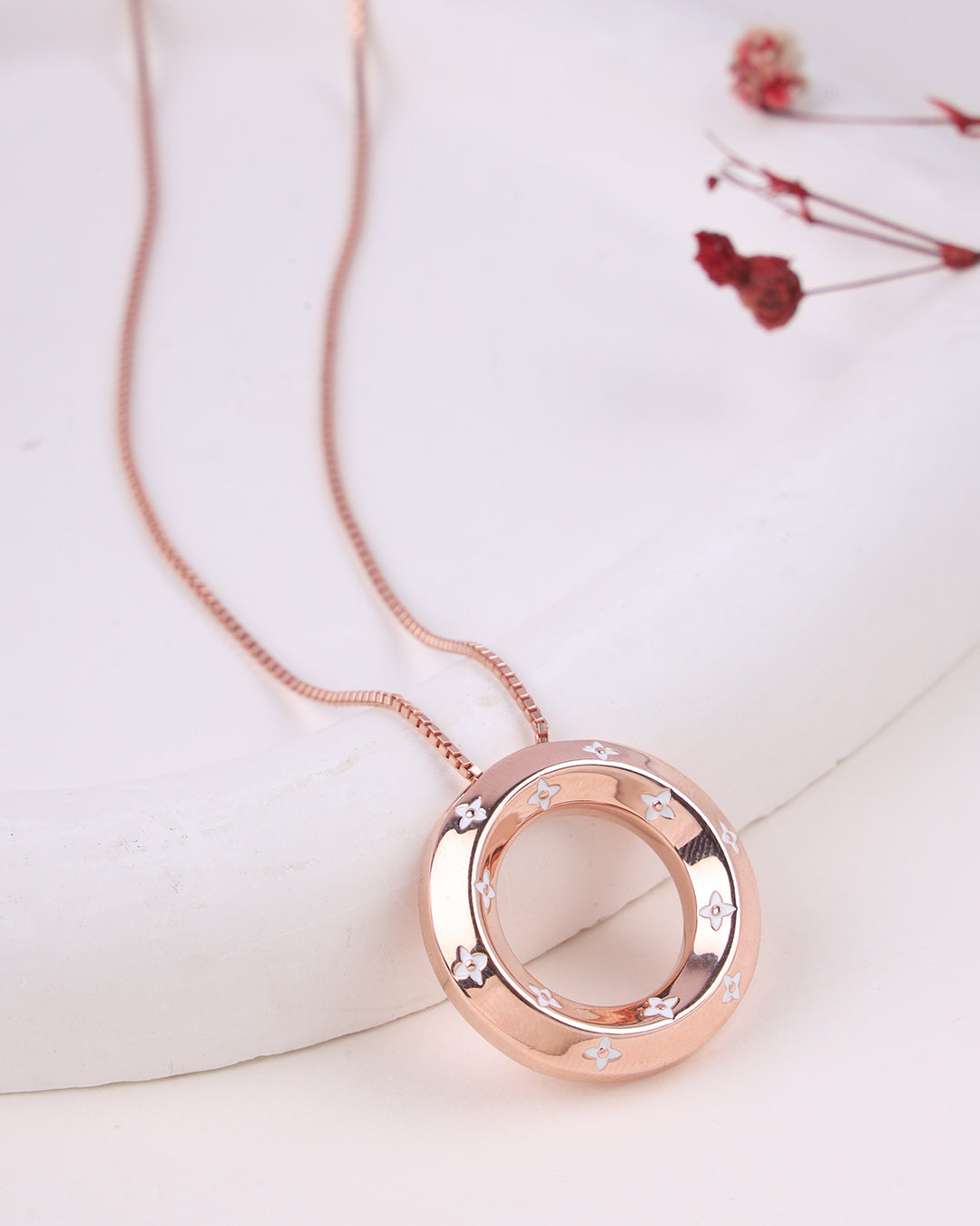 Rose gold necklace with a circular pendant on a light background