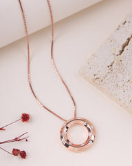 Rose gold necklace with a circular pendant on a light background