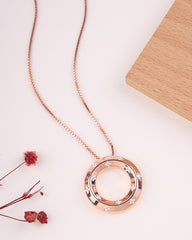 Rose gold necklace with a circular pendant on a light background