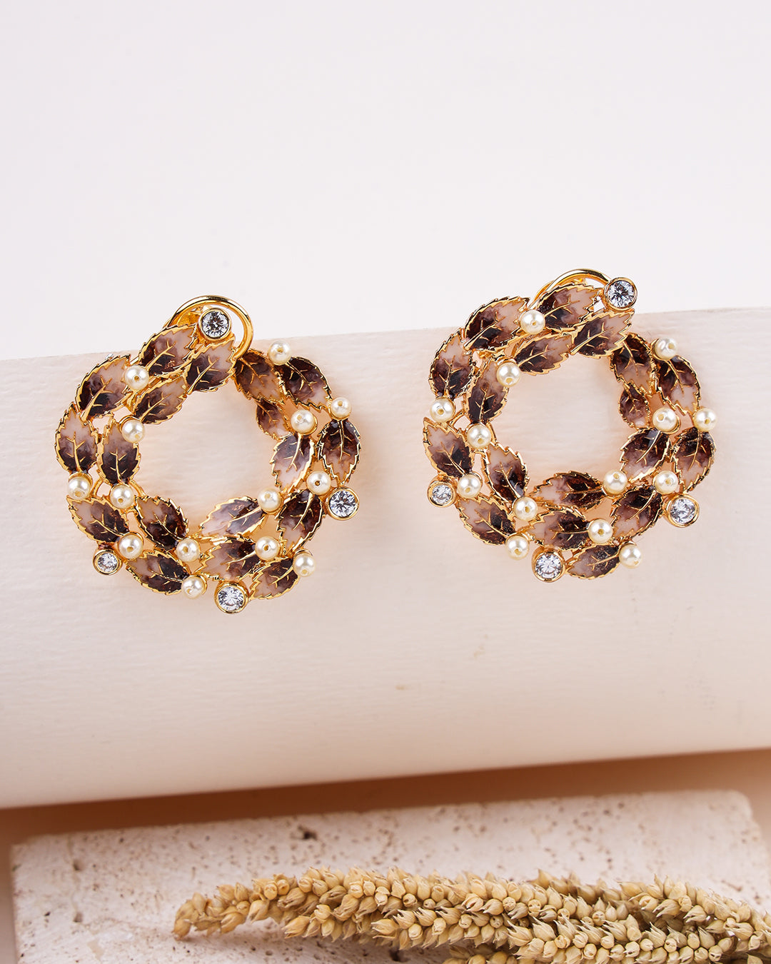 Pair of gold hoop earrings with gemstones on a white surface