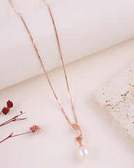 Rose gold necklace with a pearl pendant on a light background