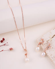 Rose gold necklace with pearl pendant on a light background