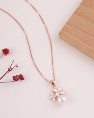 Rose gold necklace with a floral pendant on a light surface