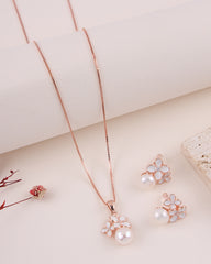 Rose gold jewelry set with floral designs on a light background