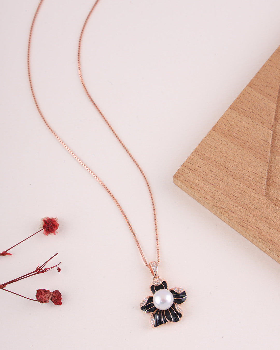 Necklace with a black and white pendant featuring a pearl on a light surface.