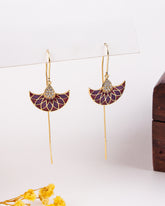 Pair of gold and purple earrings on a white background with yellow flowers.