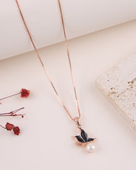 Necklace with a leaf and pearl pendant on a light surface