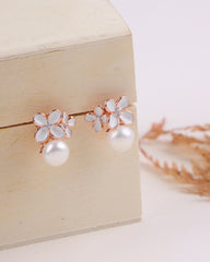 Pair of floral earrings with pearls on a wooden box