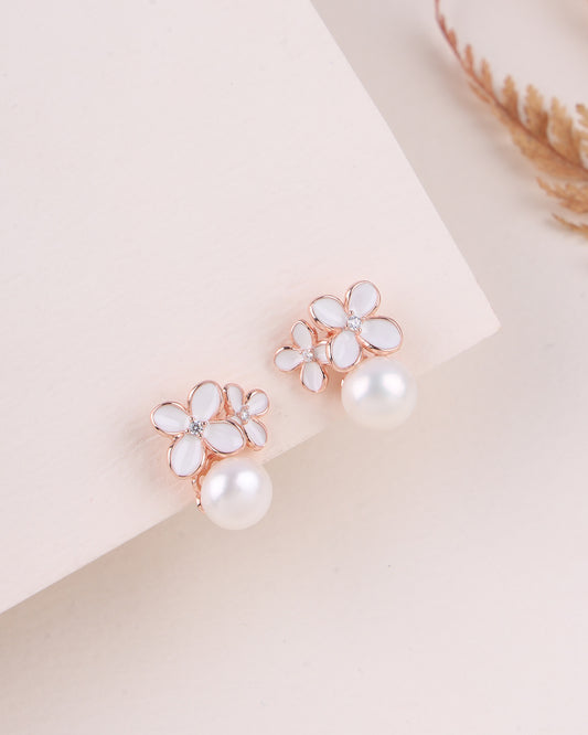 Floral earrings with pearl centers on a light background