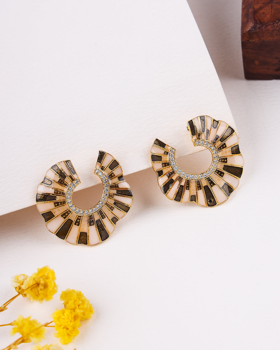 Pair of sterling silver earrings on a white surface with yellow flowers.