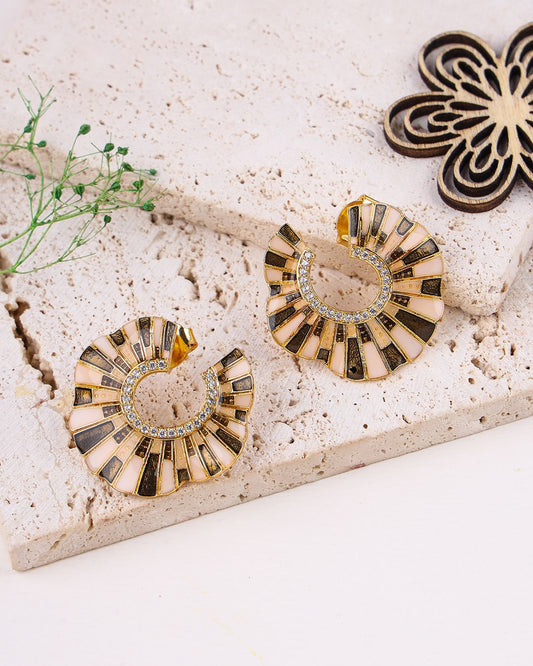 925 sterling silver earrings on a textured surface with a floral arrangement.