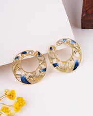 Gold and blue earrings on a white surface with yellow flowers.