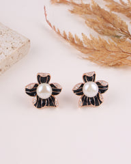 Pair of black and gold flower-shaped earrings with pearls on a light background.