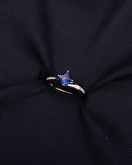 Silver Ring with a blue gemstone on a black fabric background