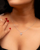 Silver necklace with a heart pendant worn by a person