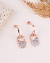 Rose gold earrings with MOP on a light background