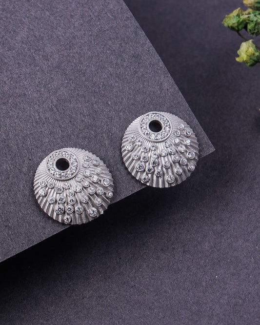 Pair of silver earrings on a dark gray surface