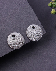 Pair of silver earrings on a dark gray surface