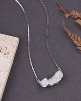 Silver necklace with a unique pendant on a dark surface