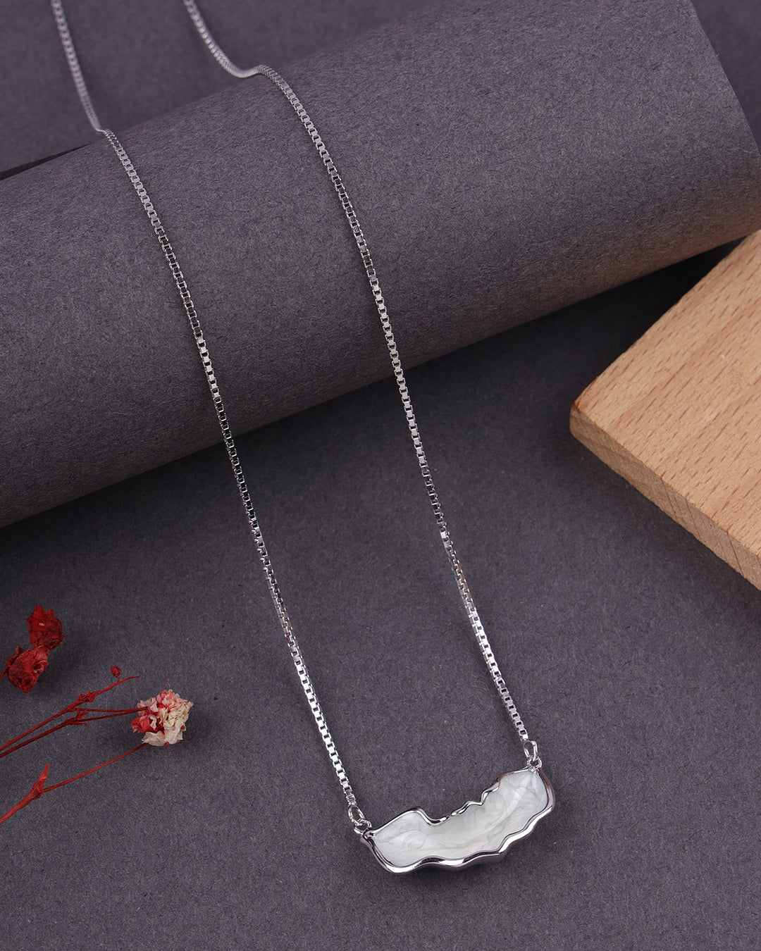 Silver necklace with a unique pendant on a dark surface