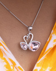 925 Sterling silver Necklace with a swan-shaped pendant featuring pink gemstones on a person wearing a yellow and white patterned garment.