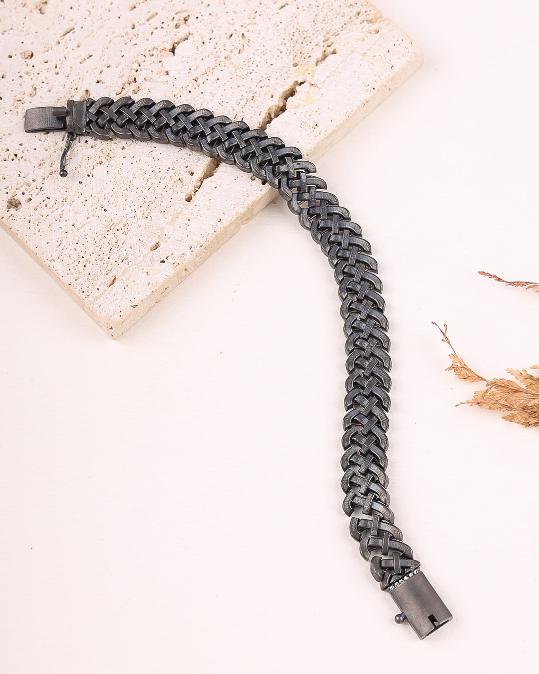 Gray braided bracelet on a light stone surface