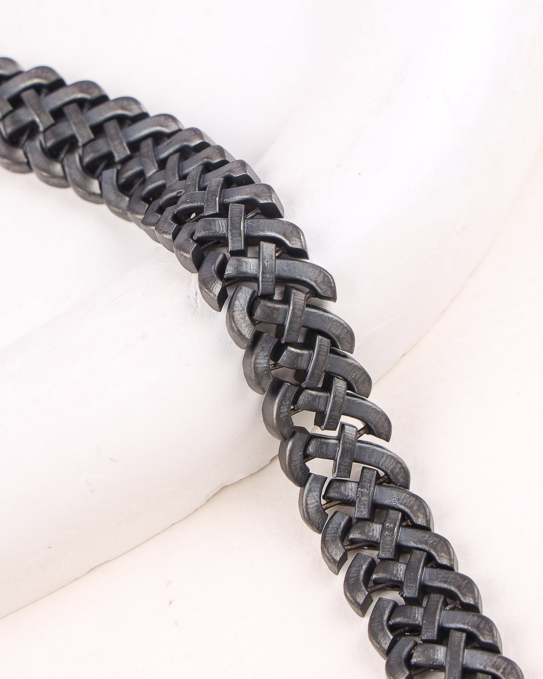 Close-up of a black chainmail bracelet on a white background