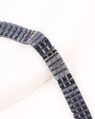 Close-up of a black and gray beaded bracelet on a white background