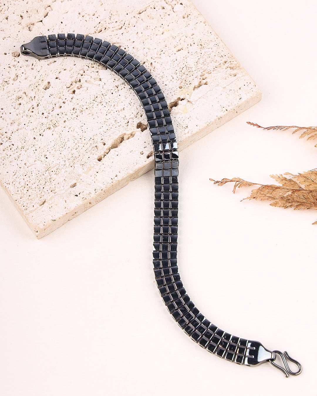 Black braided bracelet on a light stone surface