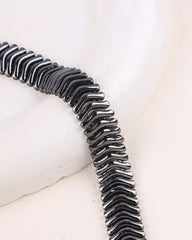 Black and silver bracelet on a white surface