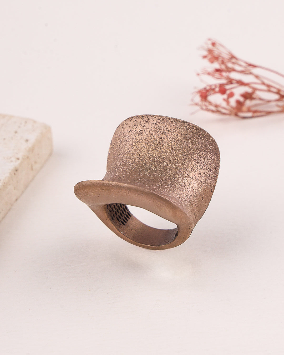 Rose gold silver ring with textured surface on a light background