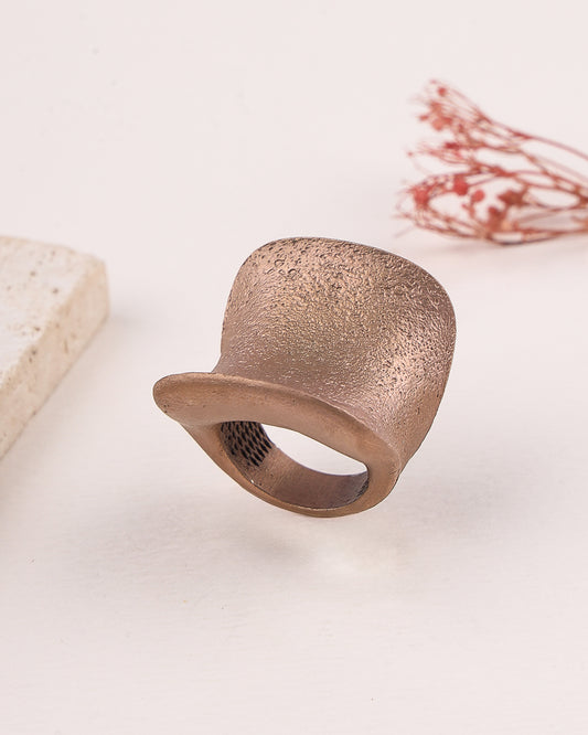 Rose gold silver ring with textured surface on a light background