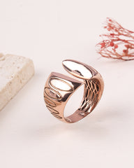 Rose gold ring with intricate design on a light background