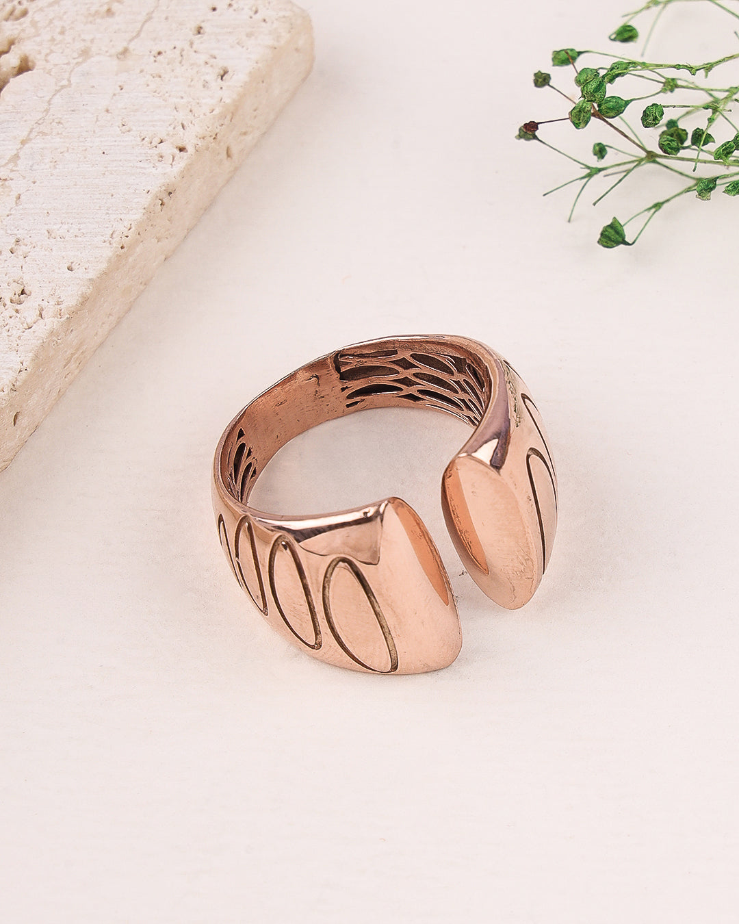 Rose gold ring on a light surface with a natural background
