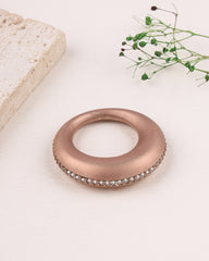 Rose gold ring with gemstones on a light background