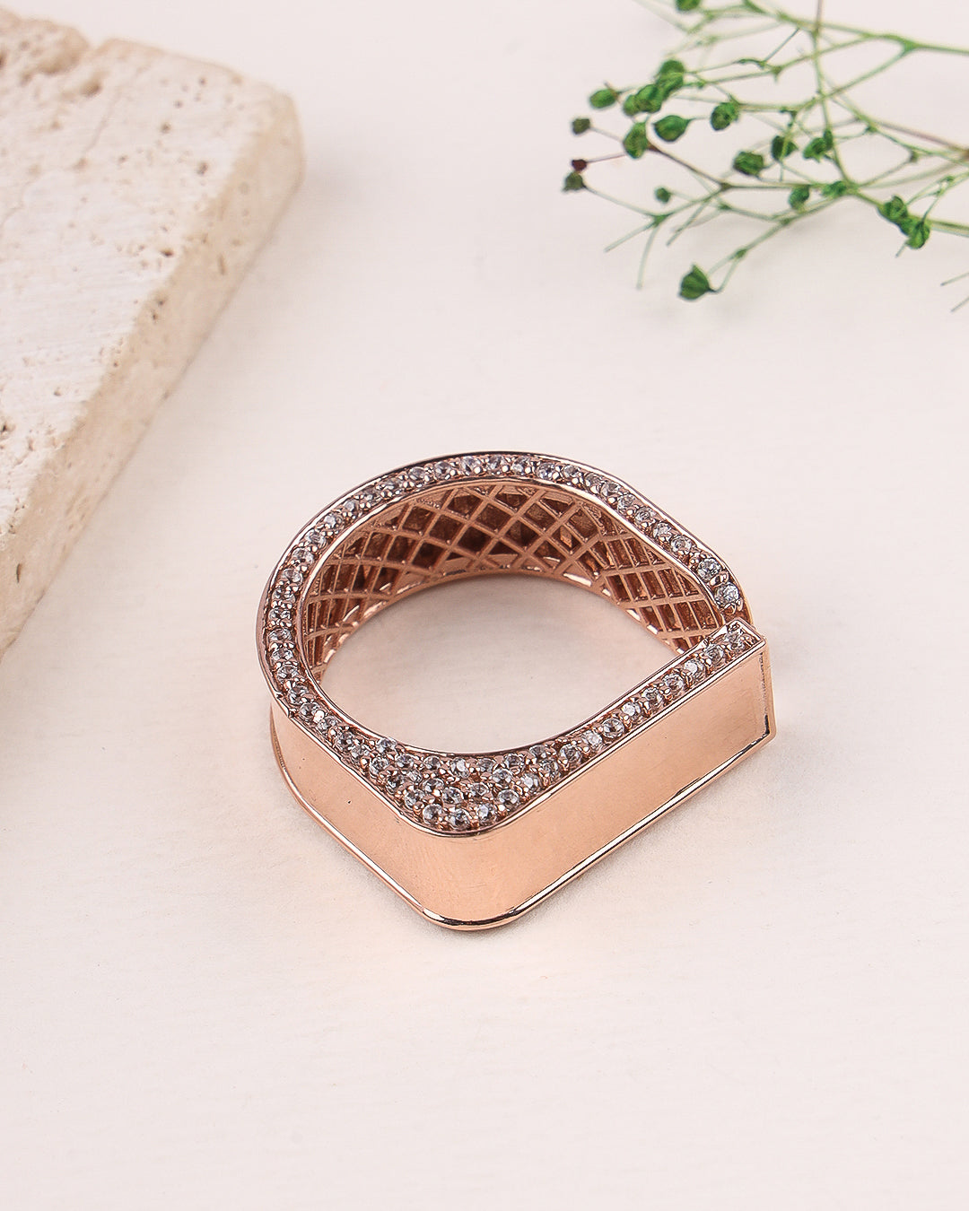 Rose gold ring with diamond accents on a light background