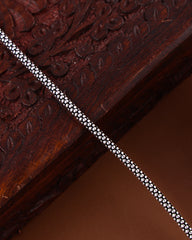 Close-up of a wooden surface with intricate carvings and a metallic strip.
