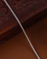 Close-up of a braided cord on a textured brown surface