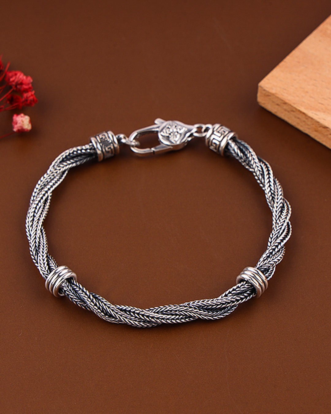 Silver braided bracelet on a brown background