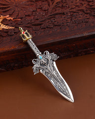 Decorative silver dagger with intricate designs on a wooden surface