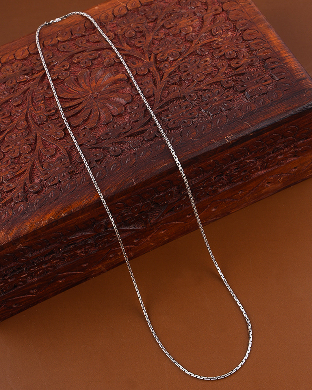 Silver chain on a wooden surface