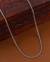 Silver chain on a textured wooden surface