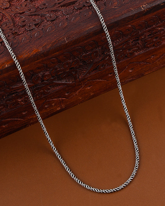 Silver chain on a textured wooden surface