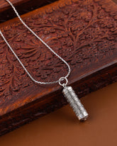 Silver pendant necklace on a wooden surface