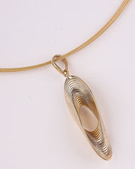 Gold necklace with a unique pendant on a light background