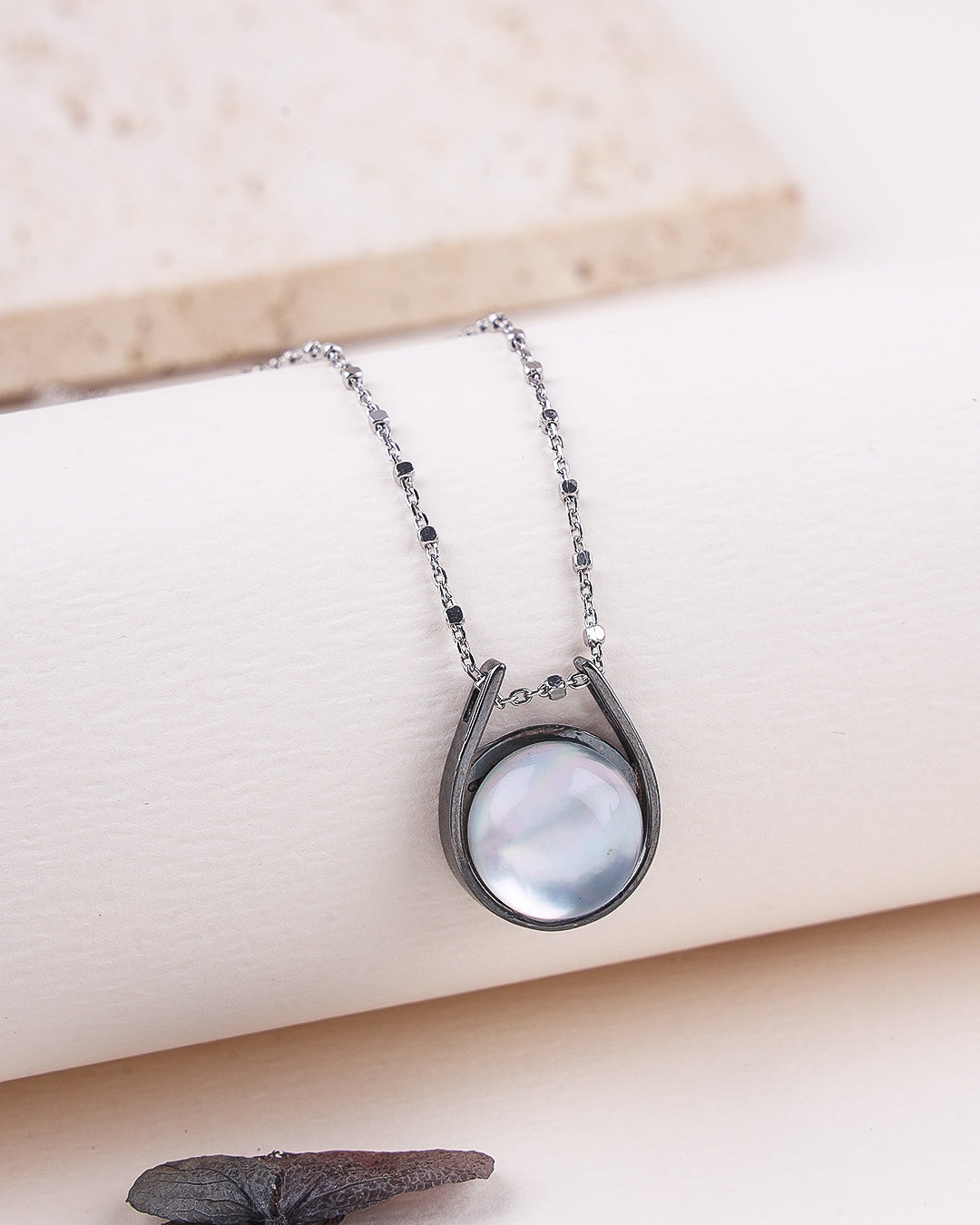 Necklace with a round pendant on a beige surface