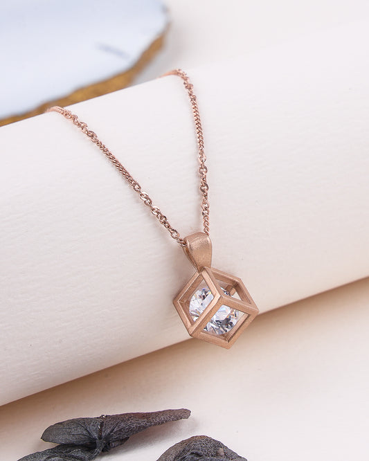 Rose gold necklace with a geometric pendant on a soft surface