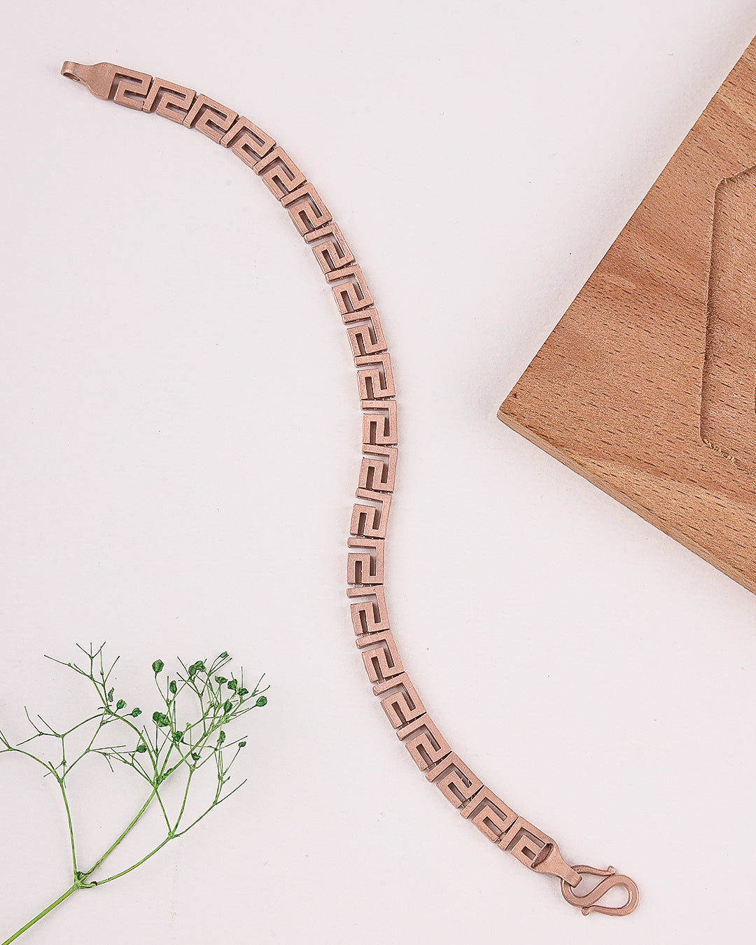 Rose gold bracelet with a geometric pattern on a light background